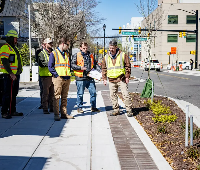 Crew reviewing a newly improved sidewalk and streetscape